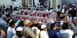 Burial services start as town grieves casualties of Pakistan train fire